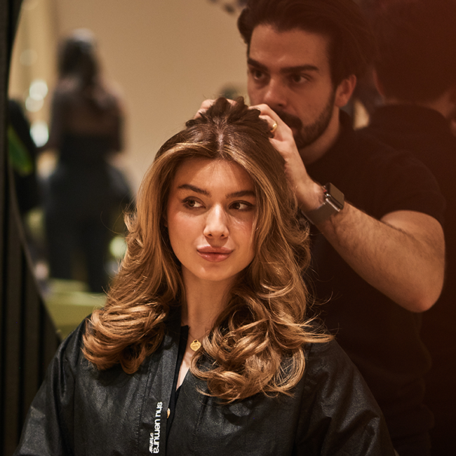 Claudio S. stylt einer Kundin im Salon die Haare als Ausdruck von Beauty, Handwerk und persönlicher Beratung